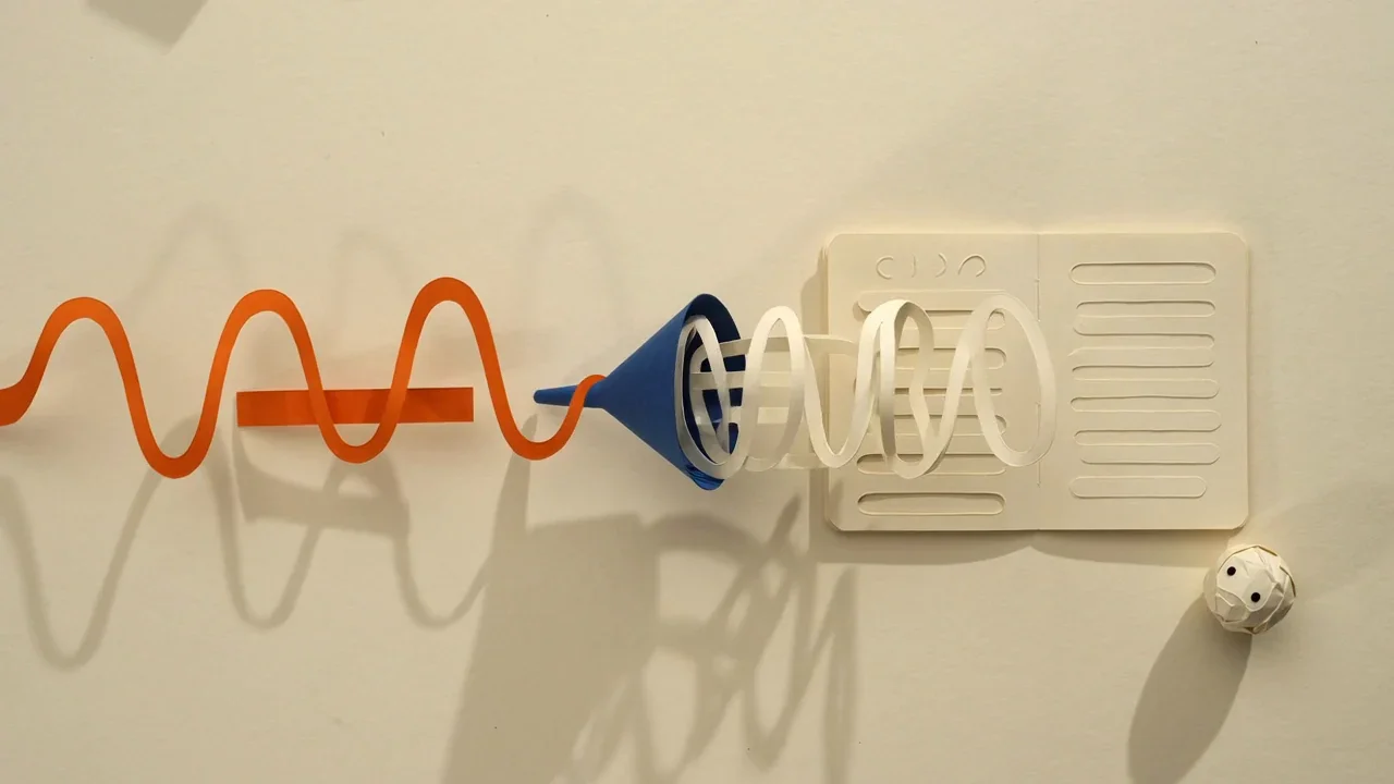 Paper-cut diagram of an orange audio waveform passing through a blue funnel and coming out as lines of text in an open notebook, showing speech becoming a transcript