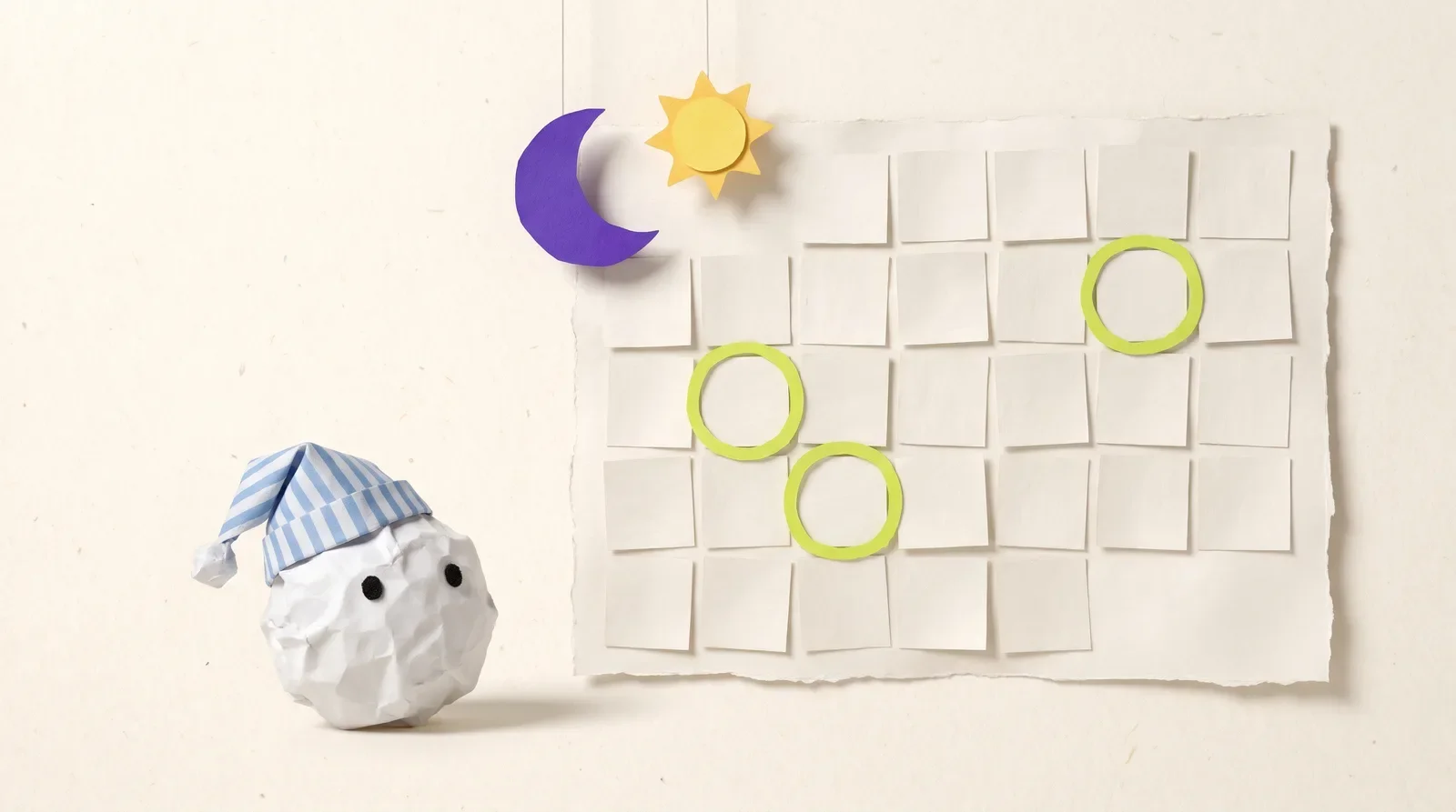 Pip the paper ball in a nightcap beside a blank paper calendar with three spaced-out days circled in lime, under a paper moon and sun